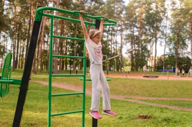 Küçük kız sabah parkta antrenman yapıyor..