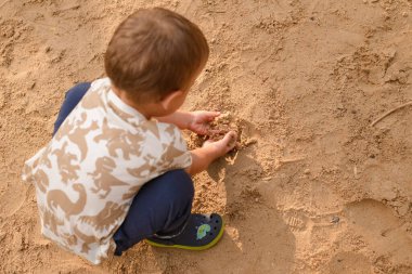 çocuk kumu kazıyor..