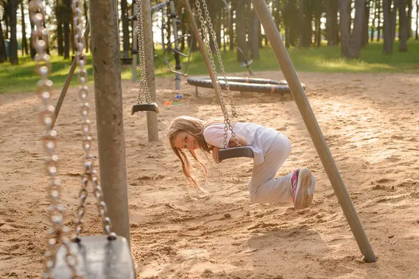 Kız çocuk parkında salıncakta sallanıyor