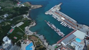 Kıbrıs 'taki rıhtımın üzerinde uçuyor. Mavi denizin kıyısında bir şehir. Yüksekten deniz manzarası. Yüksek kalite 4k görüntü
