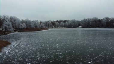 Buzlu bir gölün üzerinde uçmak. Karda ağaçlar. Güzel kış manzarası. Yüksek kalite 4k görüntü