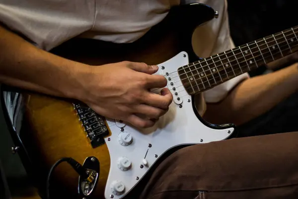 Elektro gitar çalan birinin yakın çekimi..