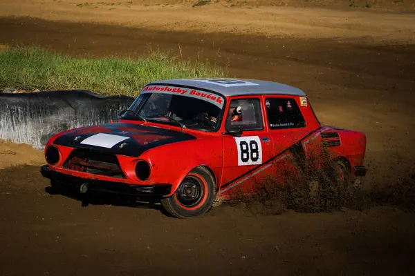 Çek Cumhuriyeti 'nde toprak üzerinde yarışan klasik kırmızı araba, havaya toprak püskürtüyor..