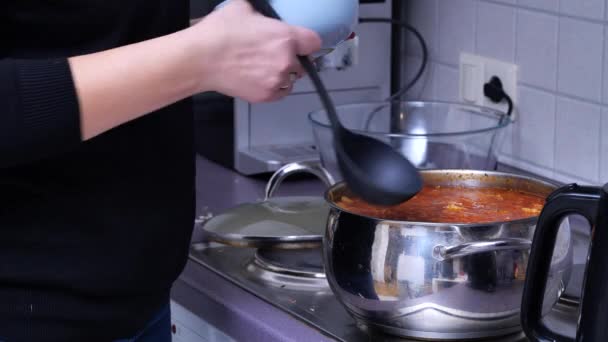 台所の女の子は皿にスープをかける — ストック動画