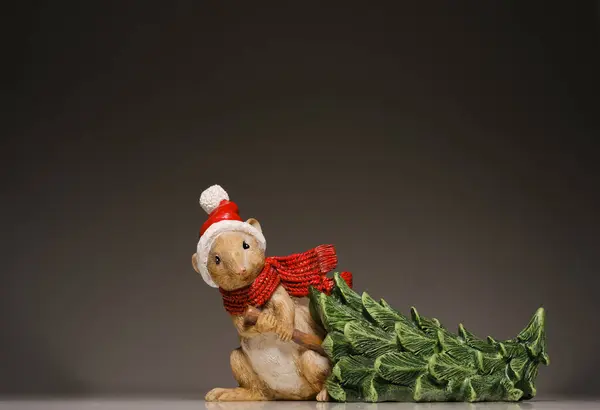 Noel Baba gibi giyinmiş şirin küçük fare ağacı deliğine çeker.