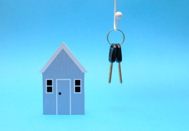 Mavi arka planda ahşap ev modeli, emlak piyasası konsepti