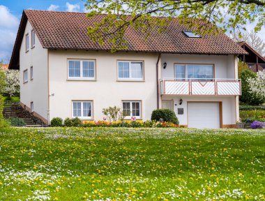 Çiçek açan baharda iki katlı bir ev.