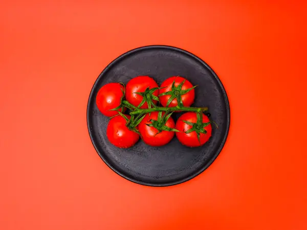 Tomates Plato Madera Negro Sobre Fondo Rojo — Foto de Stock