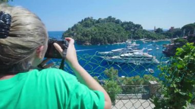 Portofino, İtalya 'da güzel yatlarla limanın fotoğraflarını çeken bir kız.