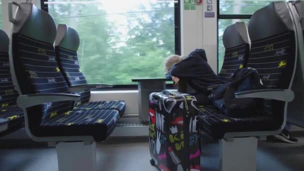 一个年轻的模特儿睡在火车上 在火车上带着手提箱的旅行女孩 睡梦中的早上通过窗口更改视图 — 图库视频影像