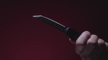 Bıçak erkeğin elinde. Bıçağı dışarı atıyor.