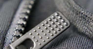 Siyah bir spor ceketin fermuarının aşırı yakın çekimi.