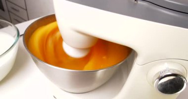 Bir pasta şefi krema yapmak için yumurtayı şekerle karıştırır..