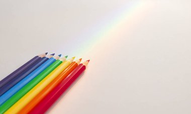 Işık zemininde çok renkli kalemler ve gökkuşağı kopyalama alanı ile.