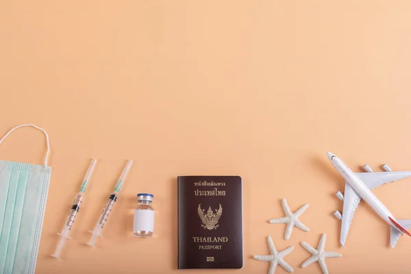 Thailand passport with aircraft model for travel in thailand after got Covid vaccine with orange pastel background