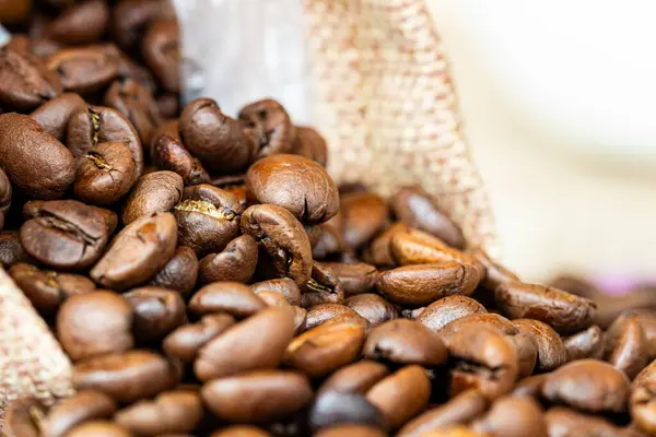 Arka planda çuval bezeli kahve çekirdekleri, mor arka planda çuval bezeli kahve çekirdekleri ve yazılar için bir yer. kahve çekirdekleri üzerine