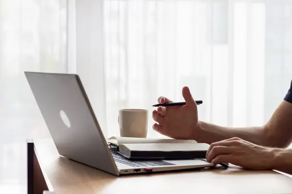 Ofiste çalışan, müzakere eden, küçük bir masadaki dizüstü bilgisayarın önünde notlar alan, açık renkli resimler, online ders veya internet toplantısı, kafe veya ofis, modern gümüş dizüstü bilgisayar