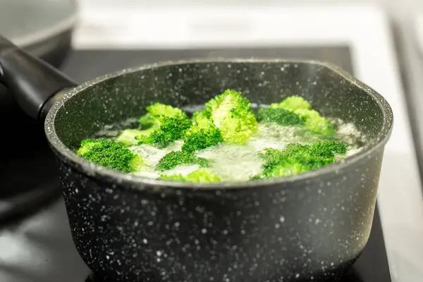 Bir tencerede kaynar suda taze yeşil brokoli.