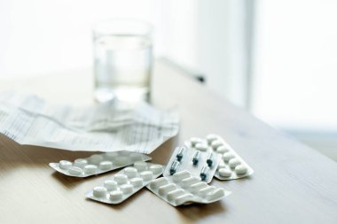 İlacın güzel görüntüsü, reçeteli ilaç ve tıbbi termometre masanın üzerinde, pencerenin arka planında. Tıpla, evde tedaviyle, salgın hastalıklarla ilgili konular için ideal