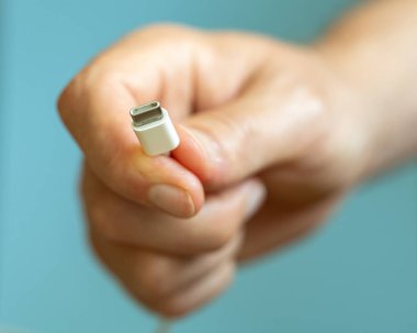 Elinde birkaç kablo tutan adam, farklı türde USB kablolar, teknoloji ve bağlantı konsepti