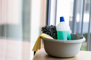  Masadaki temiz pencereye karşı bir kova temizlik malzemesi.