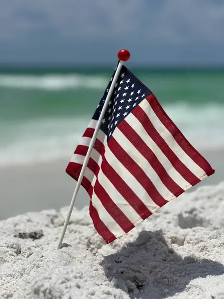 Deniz manzaralı kumsalda Amerikan bayrağının seçici odak noktası 