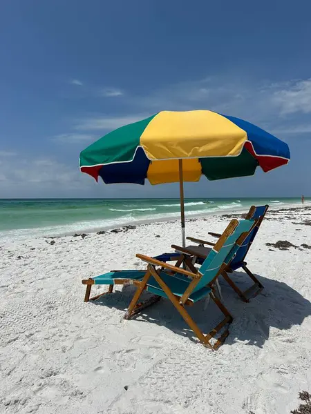 Destin, Florida 'da Meksika Körfezi manzaralı renkli plaj şemsiyesi ve sandalyeler. 