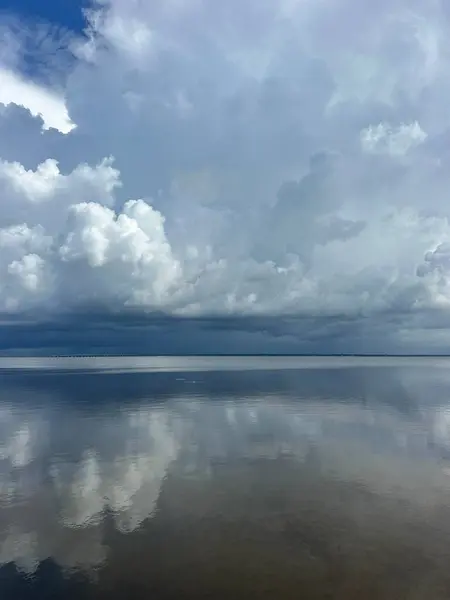 Fırtınalı gökyüzü, Miramar Sahili, Florida 'daki ChoctaWhatchee Körfezi' ne yansıyor. 