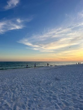 Güneşin batışı Emerald Coast Florida sahillerinde siluetlerle 