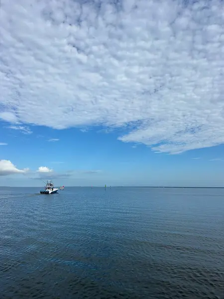 Florida 'da kabarık beyaz bulutlu ChoctaWhatchee Körfezi' nde bir tekne. 