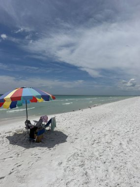 Renkli plaj şemsiyesi ve Meksika Körfezi manzaralı sandalyeler Emerald Coast Florida 