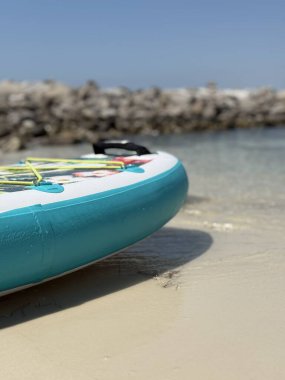 Florida, Destin 'deki Norriego Plaj Noktası' nda kayalık jettileri ve su geçmişi olan kürek tahtasının seçici odak noktası 