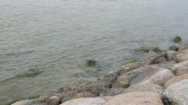 Sağdan sola doğru yavaş tava ve kıyıya vuran yumuşak dalgalar.