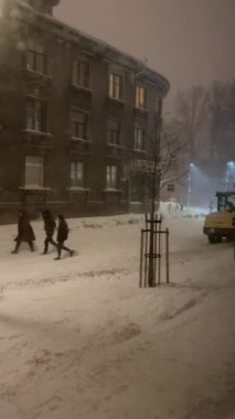 Yoğun bir kar fırtınasında yürüyen insanların dikey videosu