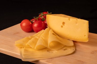 Tahtada duran sarı peynir, turuncu peynir ve domates kompozisyonu, yakın plan..