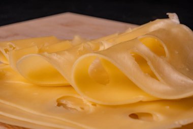 Sarı peynirin yakın çekim görüntüsü, katmanlar halinde kesilmiş..
