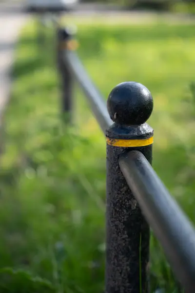 black fence post with yellow stripe