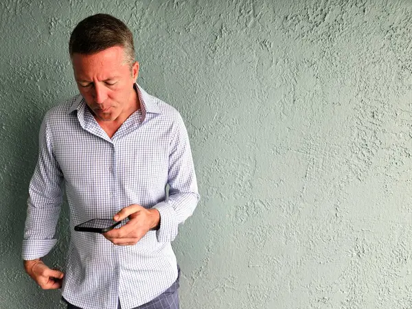 Mobil aygıt üzerinde mavi arkaplan üzerinde X nesli profesyonel metin aşağı düğmeli gömlek giyer.