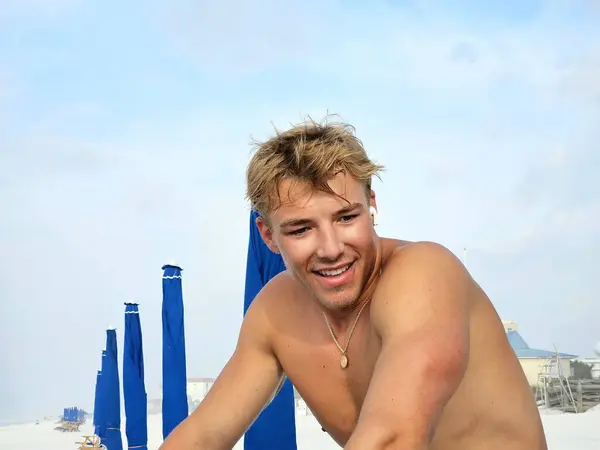 Plajda turistlerin rahatlayıp okyanusun tadını çıkarması için plaj sandalyeleri kuran havalı bir adam..