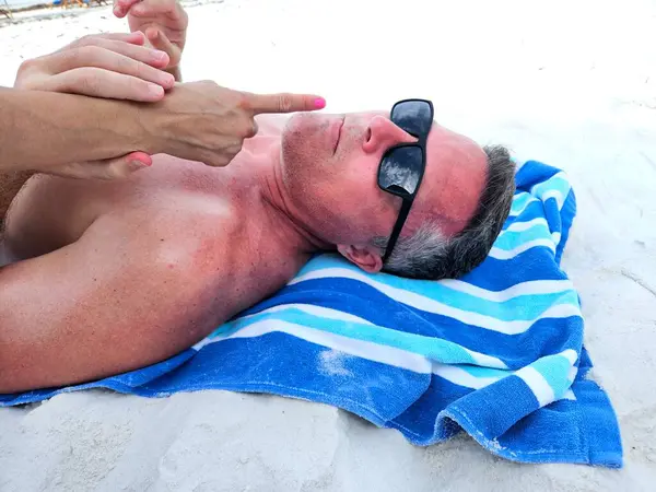 Karısı X kuşağını işaret ederek Florida plaj tatilinde güneş yanığı olasılığına karşı uyardı.. 