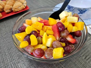 Partide karpuzlu, kavunlu ve üzümlü bir kase meyve salatası..