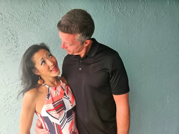 Mavi arka plan duvarına yaslanmış mutlu çift gece planları yapmaya karar verdi..