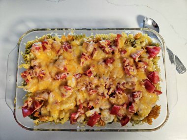 Tepeden tırnağa peynirli ve domatesli bir Pyrex tabağında pişmiş karides makarnası vardı.. 