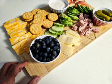 Masa üstü yemek masası meyve ve sebzelerle dolu. Ayrıca indirimli içki partisi için kraker ve peynir..