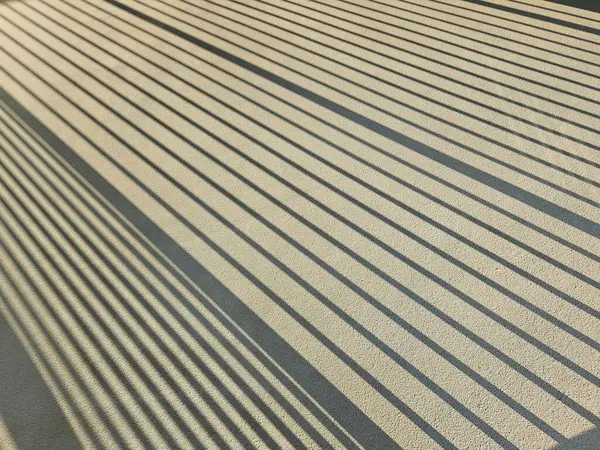 Paralel çizgilerin gölgeleri Bannister 'dan aydınlık ve gölgeli apartman yolunda.