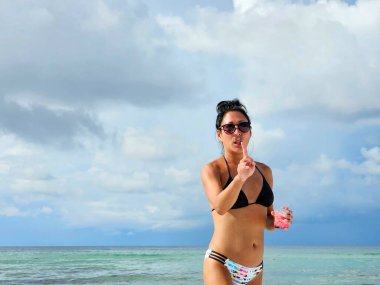 Duygusal Asyalı nesil X kadın plaj tatilinde alkollü içecek içiyor.. 