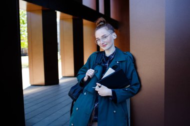 Öğrenci ya da gözlüklü, sırt çantalı ve modern geçmişi olan bir işçi kız.