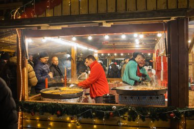 Polonya Poznan 'da ziyaretçiler için geleneksel Polonya sokak yemekleri hazırlayan Noel çalışanları