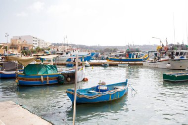 Malta 'daki Marsaxlokk balıkçı köyü yakınlarında demirlemiş renkli Malta luzzu tekneleri.