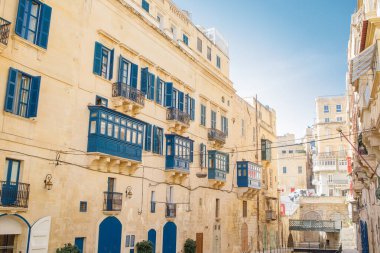 Valletta, Malta 'nın merkezinde eski mimarisi ve mavi balkonları olan büyük bir cadde.